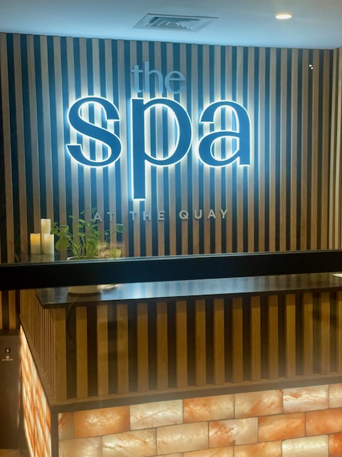 The Spa entrance at The Quay Hotel, featuring a modern wooden panel backdrop and illuminated signage.