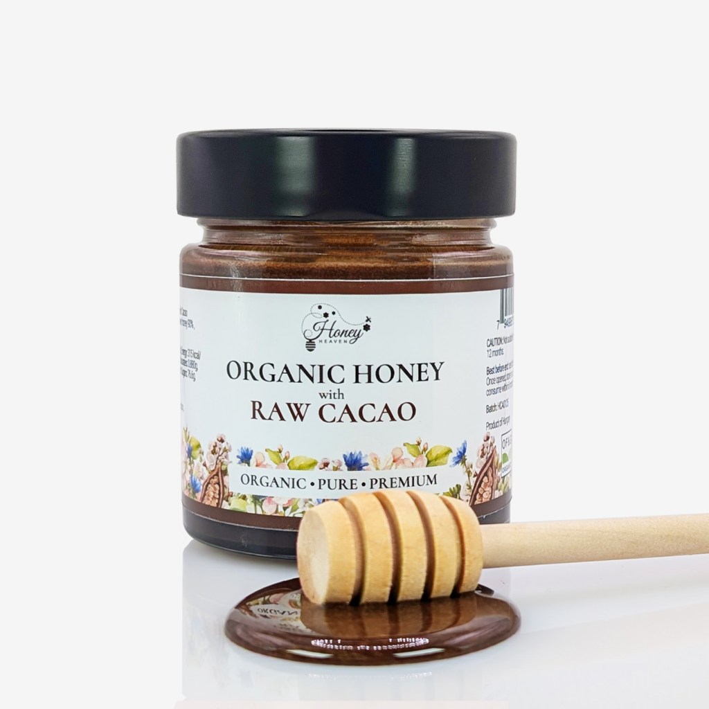 A jar of organic honey with raw cacao, featuring a wooden honey dipper and a glossy honey pool.