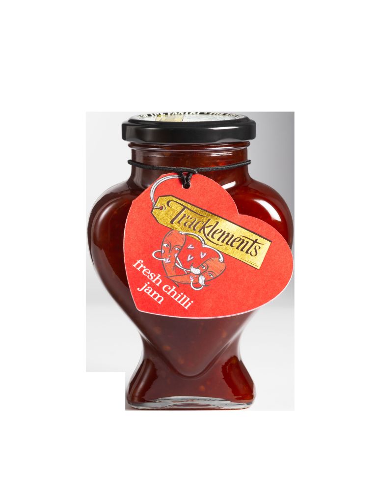 A jar of Tracklements fresh chilli jam, featuring a heart-shaped glass design and a red label with a playful graphic.