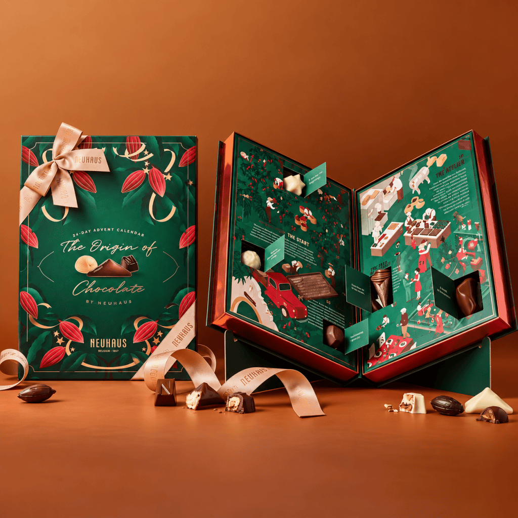 A beautifully designed advent calendar titled 'The Origin of Chocolate' by Neuhaus, featuring colorful illustrations and chocolates. The calendar is opened to reveal different compartments holding various chocolates, along with informative sections about the chocolate-making process.
